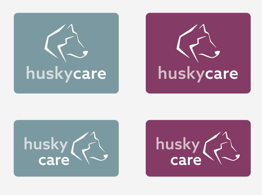 Logo der Pflegemanagement-Software HuskyCare, das den abstrakten Kopf eines Huskys darstellt. Abgebildet sind zwei Farbversionen mit Rauchblau und Beere.