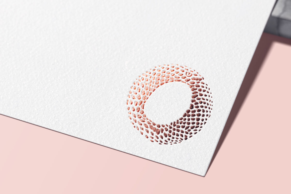Abbildung des Logos für das Forschungsprojekt „Orthpol“, welches aus einer abstrakten, sich in den Schwanz beißenden Schlange, einem Ouroboro, besteht. Das Bild zeigt das Signet mit Metallfolie gedruckt
